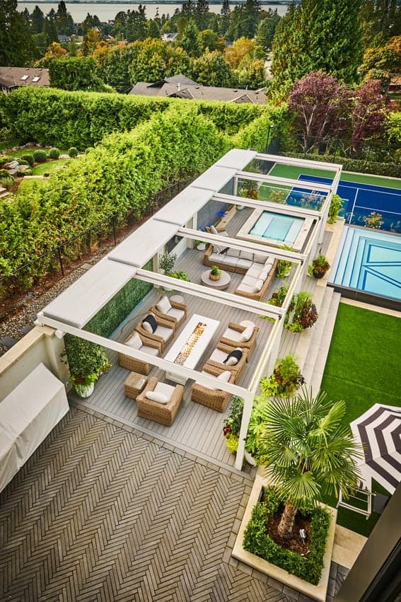 Vue aérienne de pergolas à toiture rétractable au-dessus d’un salon d’extérieur, près d’une piscine